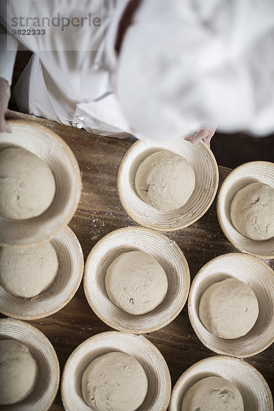 Bäckerin bereitet Keramikschalen zum Brotbacken vor