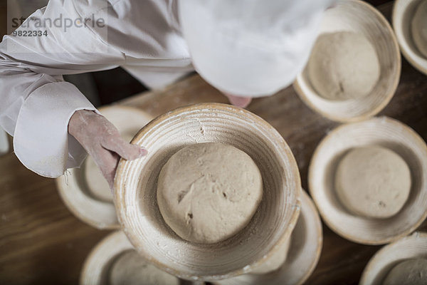 Bäckerin bereitet Keramikschalen zum Brotbacken vor