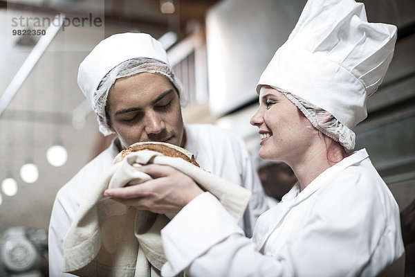 Bäckerin erregt über gebackenes Brot frisch aus dem Ofen