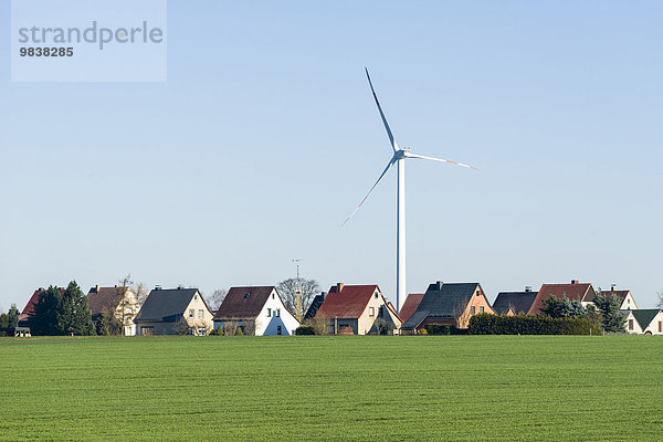 Windkraftanlage an einem Dorf mit Häusern in einer Agrarlandschaft  Räckelwitz  Sachsen  Deutschland  Europa