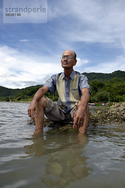 Alter Mann blickt auf das Meer  dem beim Tsunami 2004 fast seine gesamte Familie zum Opfer gefallen ist  Dorf Lam Rukam  Subdistrict Rozma  Aceh  Sumatra  Indonesien  Asien