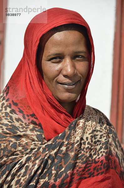 Porträt einer Nubierin in typisch buntem Gewand vor ihrem Haus im Dorf Umogaal  bei Dongola  Niltal  Nubien  Sudan  Afrika