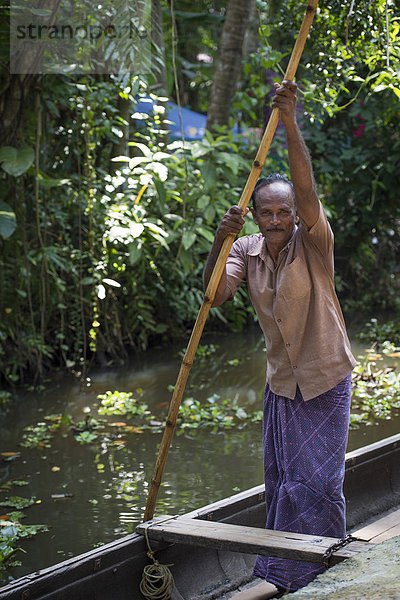 Mann in einem Stocherkahn  Kanalsystem Backwaters  bei Alappuzha  Kerala  Indien  Asien