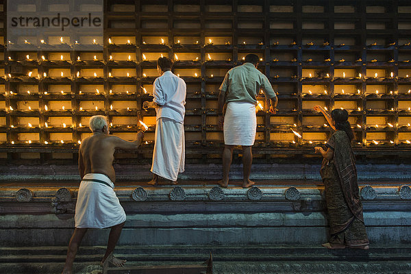 Öllämpchen für hinduistische Feuerzeremonie Aarti werden in Nischen an der Außenwand des Tempels entzündet  Ambalapuzha  Kerala  Indien  Asien