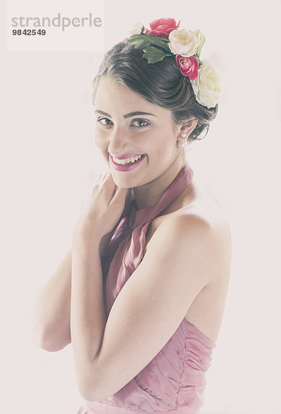 Beauty-Portrait einer lachenden jungen Frau mit Blumen im Haar