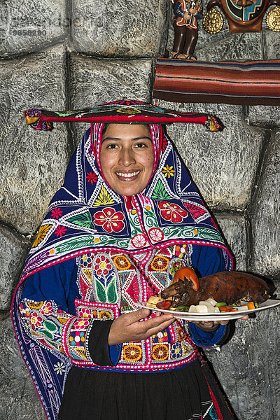 Frau serviert gebratenes Meerschweinchen Cuy chactado  Custo  Peru  Südamerika