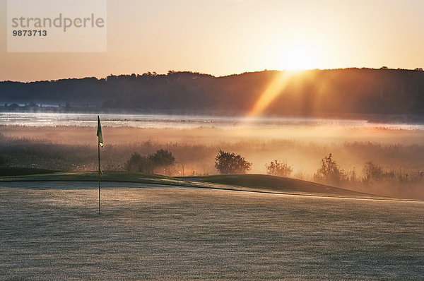 glühend Glut Berg Beleuchtung Licht über grün Morgendämmerung Golfsport Golf Kurs Sonne