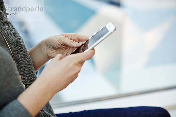 Eine Frau mit einem Smartphone in der Hand.