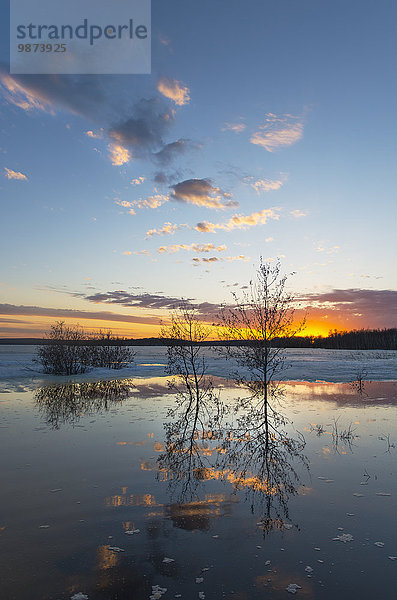 Ein See bei Sonnenuntergang. Eis schmilzt auf der Wasseroberfläche.