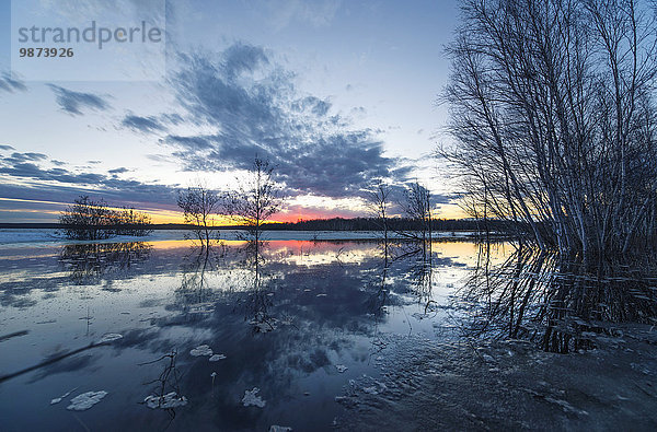 Ein See bei Sonnenuntergang. Eis schmilzt auf der Wasseroberfläche.