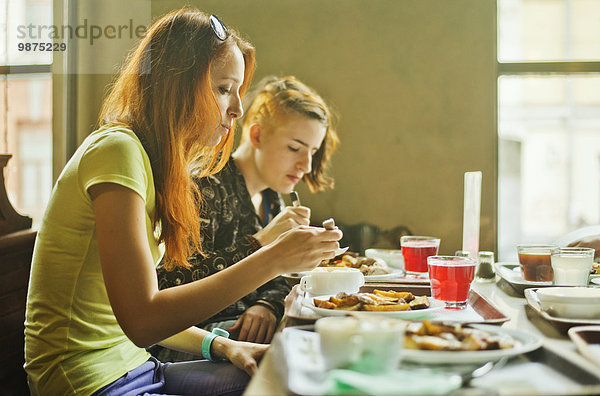 Europäer Frau am Tisch essen Zimmer essen essend isst