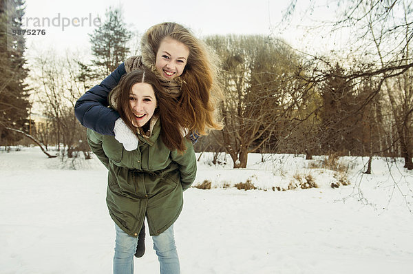 Europäer Frau tragen Schnee Feld huckepack Freund