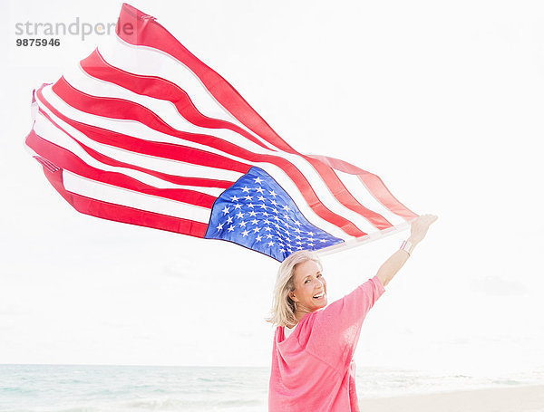 Europäer Frau Strand halten Fahne amerikanisch alt