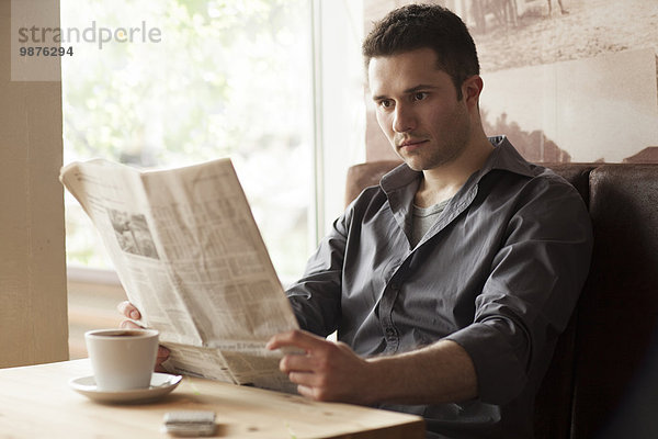 Mann Cafe trinken Kaffee Zeitung vorlesen