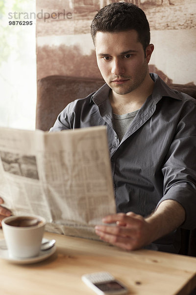 Mann Cafe trinken Kaffee Zeitung vorlesen