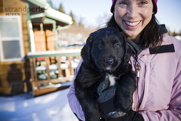 nahe Außenaufnahme junge Frau junge Frauen Berg Winter halten Hund Hintergrund Kabine freie Natur Welpe