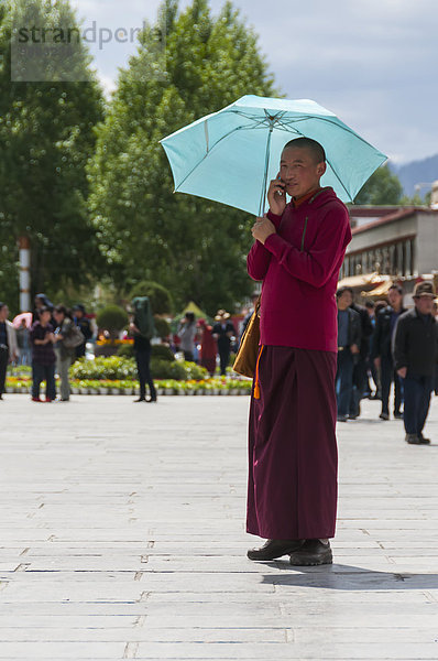 Handy Schutz Regenschirm Schirm halten Sonnenlicht jung Beruf Lhasa Mönch Tibet