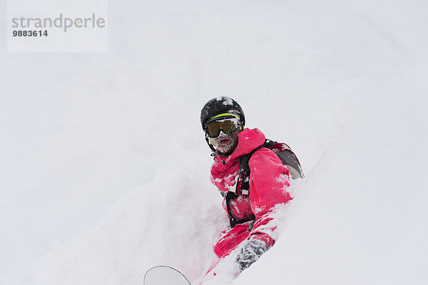 sitzend Snowboardfahrer Pulverschnee Gesichtspuder Kanton Graubünden tief Schnee