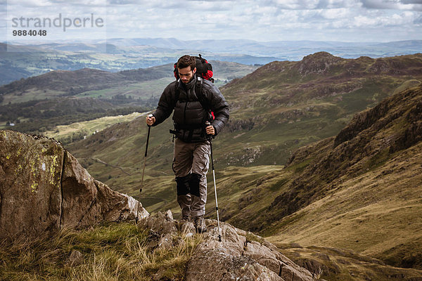 Junge männliche Wanderer  die sich auf den Berg bewegen  The Lake District  Cumbria  UK