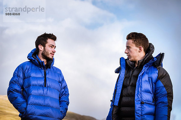 Zwei junge männliche Wanderfreunde im Gespräch  The Lake District  Cumbria  UK