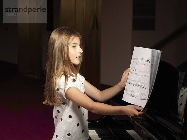 Mädchen wählen Noten für Klavier