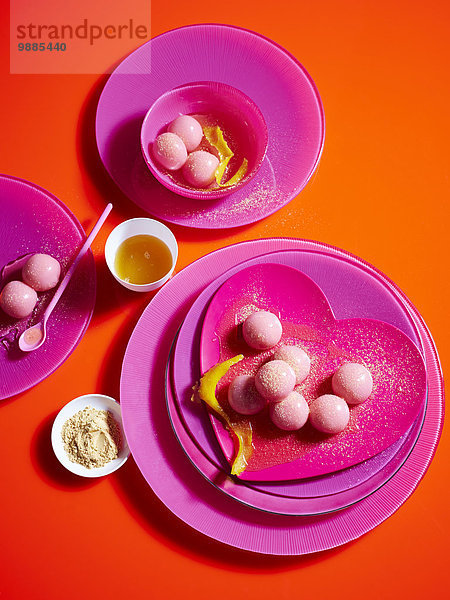 Stilleben mit rosa Tellern und klebrigen Reisknödeln