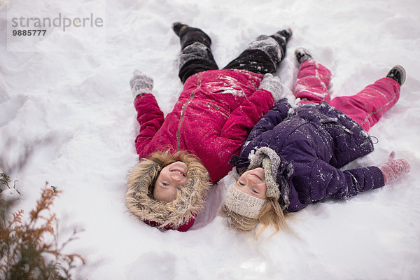 Schwestern spielen draußen im Schnee