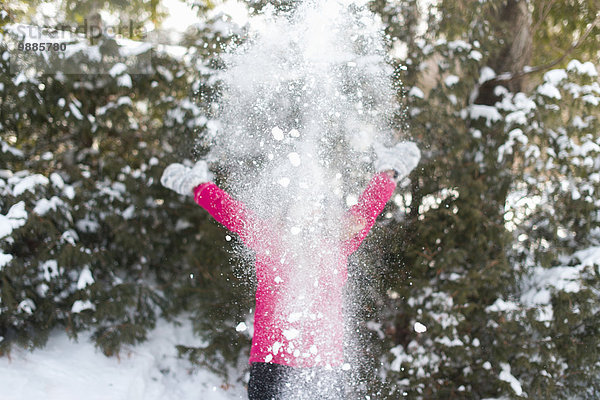 Mädchen spielt draußen im Schnee