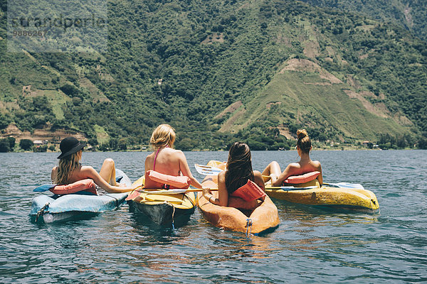 Rückansicht von vier jungen Freundinnen beim Kajakfahren auf dem Lake Atitlan  Guatemala