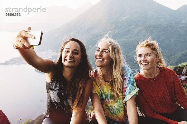 Drei Freundinnen nehmen Smartphone Selfie am Lake Atitlan  Guatemala