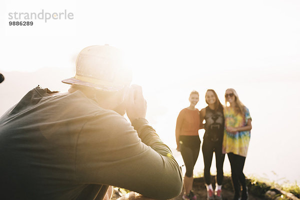 Junger Mann fotografiert weibliche Freunde am Lake Atitlan mit Digitalkamera  Guatemala