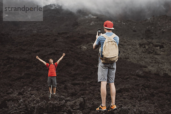 Junger Mann fotografiert Freund am Vulkan Pacaya  Antigua  Guatemala
