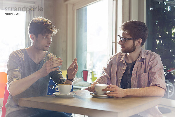 Männer reden und trinken Kaffee im Cafe