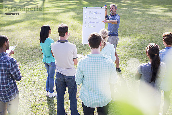 Mann führt Treffen bei Flipchart im Feld an