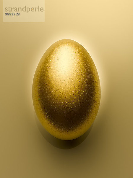 Overhead-Ansicht des goldenen Eies auf goldenem Hintergrund Stillleben