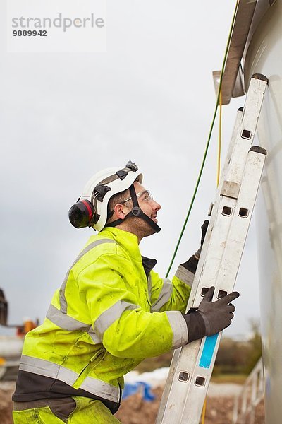 Ingenieur klettert Leiter  arbeitet an Windkraftanlage
