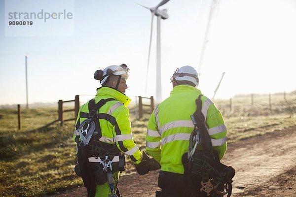 Zwei Ingenieure im Windpark  gemeinsam unterwegs  Rückansicht