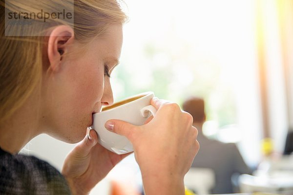 Junge Frau trinkt Kaffee im Café  Nahaufnahme