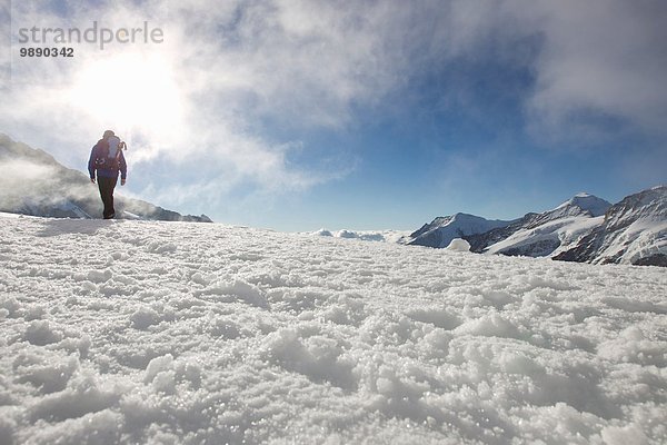 Tiefblick auf den männlichen Wanderer in verschneiter Landschaft  Jungfrauchjoch  Grindelwald  Schweiz