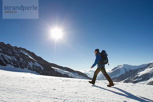 Mann wandert durch verschneite Berglandschaft  Jungfrauchjoch  Grindelwald  Schweiz
