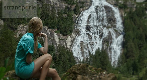 Frau beobachtet Wasserfall