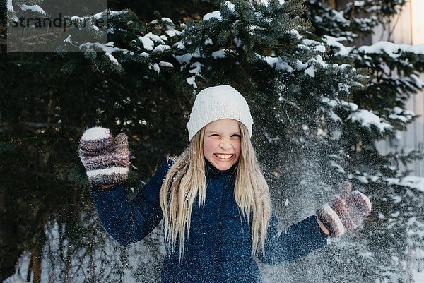 Mädchen grinst vor Aufregung über den Schnee