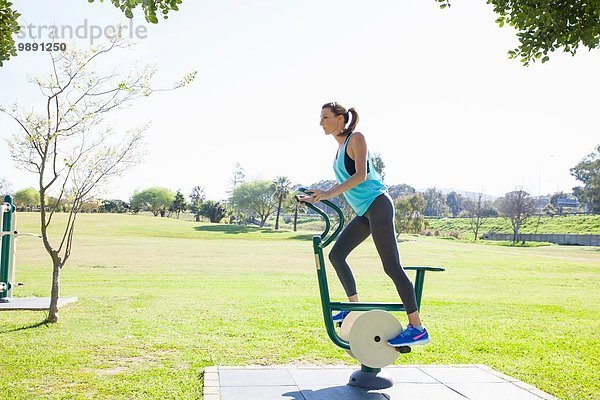 Mittlere erwachsene Frau beim Training auf dem Heimtrainer im Park