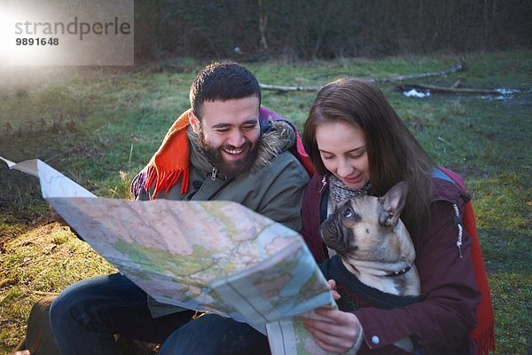 Junges Wanderpaar beim Kartenlesen im Wald