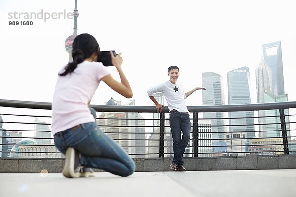 Männliche Touristen posieren für Freundin mit Sofortbildkamera  The Bund  Shanghai  China