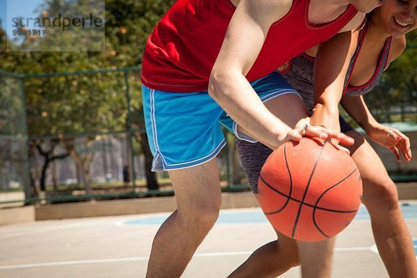 Junges Paar beim Basketball auf dem Platz