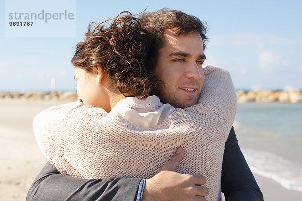 Junges Paar umarmt sich am Strand  Tel Aviv  Israel