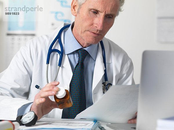 Arzt prüft medizinische Notizen vor der Verschreibung von Medikamenten