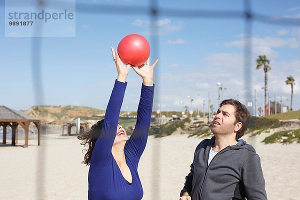 Junges Paar wirft Ball am Strand  Tel Aviv  Israel