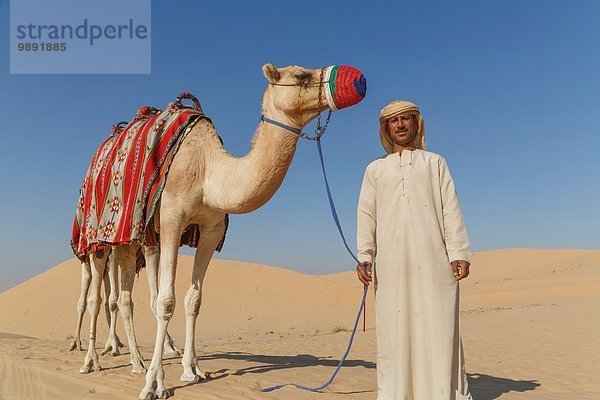 Porträt eines Beduinen mit Kamel in der Wüste  Dubai  Vereinigte Arabische Emirate